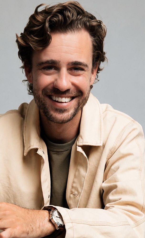 Portret van Beau Schneider, lachend, in een licht jasje
